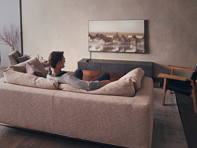 Man sitting on couch watching SONY TV